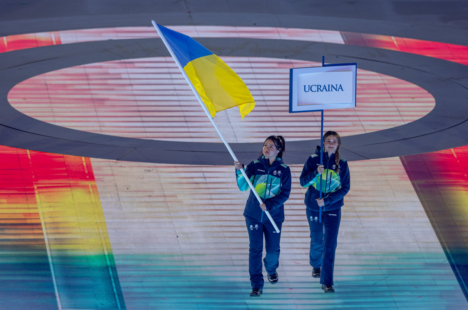 Toimitsijat kantavat Ukrainan lippua avajaismarssissa.